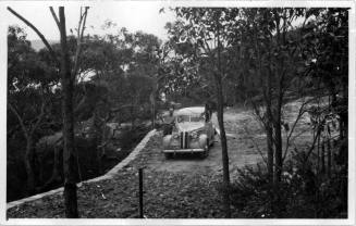 View of Oskar Speck leaning against his BMW car, at his house in Killcare