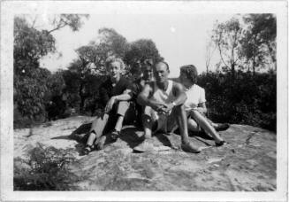 View of Oskar Speck and friends sitting on a rock slab