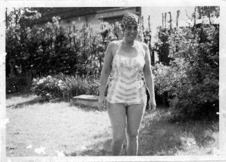 View of a woman wearing a swimsuit in a backyard