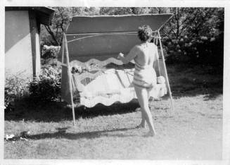 View of a woman wearing a swimsuit near a covered swing seat