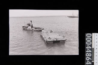 A tug towing a landing stage in Aden Harbour, Yemen