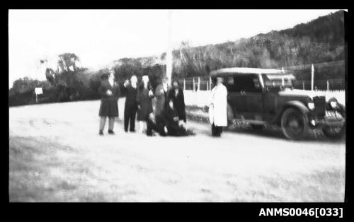 Group of people standing near a motor vehicle