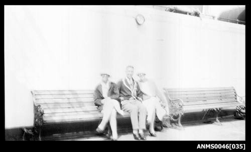 A man and two ladies seated on a bench