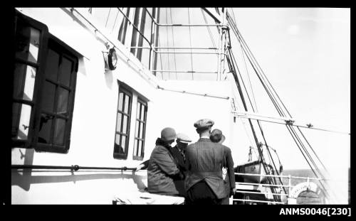 Rear view of four people seated and standing on the deck of SS KATOOMBA