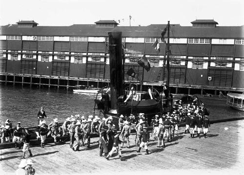 Royal Navy sailors and officers disembark from a tug at Woolloomooloo Bay in Sydney