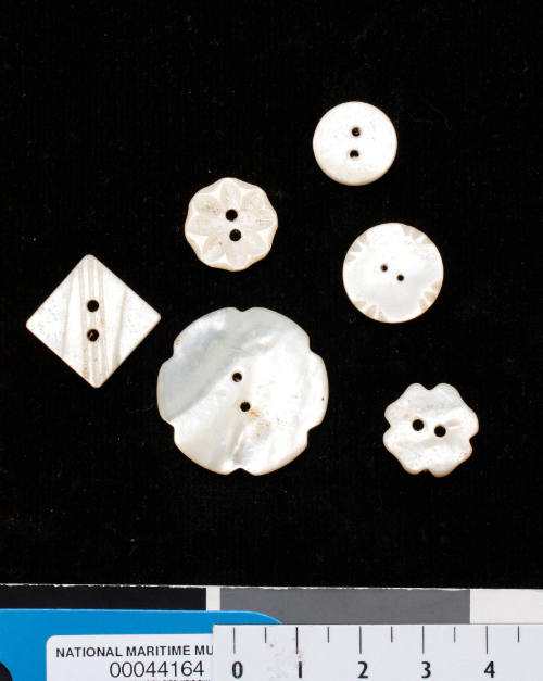 Six pearl shell buttons of varying sizes and shapes