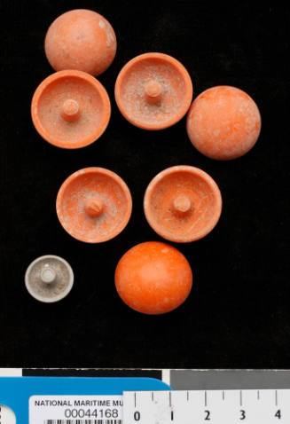 Eight plastic caps, semi-circle in shape with a raised area in the hollow centre, probably used to create nuclei