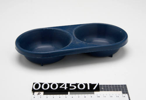 Blue plastic dog bowl, with two individual bowls, used alongside the pearl polishing machine (00045016)