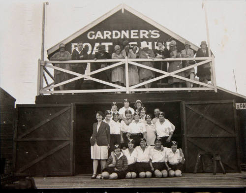 Portrait of rowers and onlookers outside Gardner's boatshed, Sydney