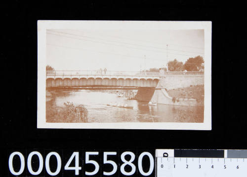 Postcard of a boat rowing under a bridge