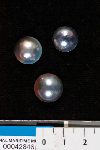 Three small grey cultured half pearls (or mabe pearls) with shell bases