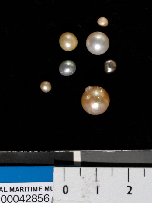 Seven spherical and slightly misshapen pearls