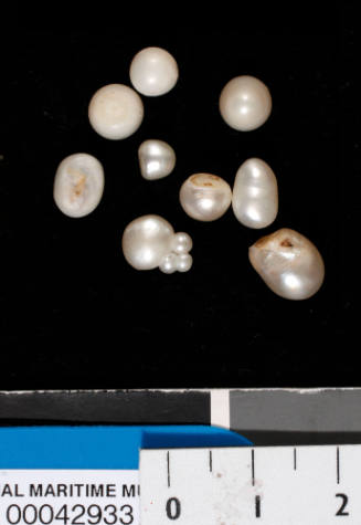 Nine small irregularly shaped white pearls