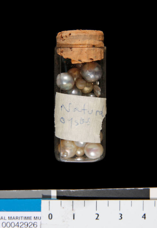 Cylindrical glass container with cork stopper, used to store pearls