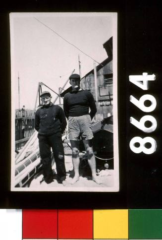 Wee' Georgie Robinson and Bob Lundie standing beside BRITANNIA's rigging in Georgie 's boatyard in Balmain