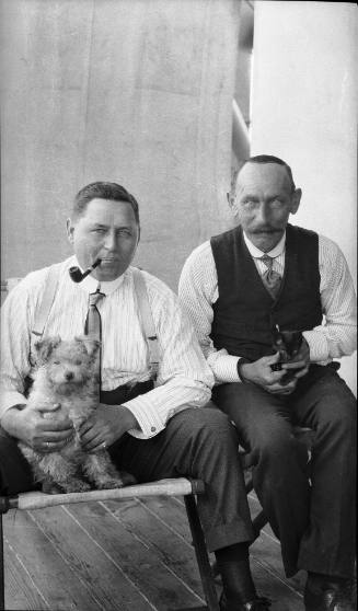 Two crew members with pet dog and cat