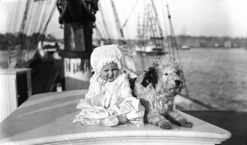 Baby and a dog on a sailing ship