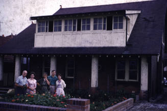 Portrait of five people in front of 5 Roma Ave. slide