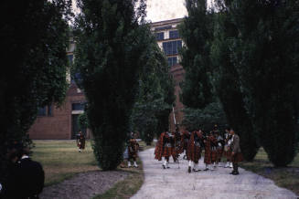 Highland gathering of pipers in red tartan silde