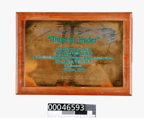 Brass plaque commemorating the naming of TRANZTAS TRADER mounted on a wooden base