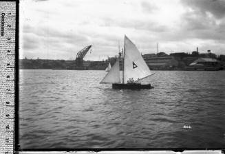 12-foot skiff displaying a triangle emblem on the mainsail, Sydney Harbour