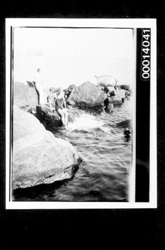 Group swimming at a rocky seashore