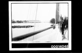 Yacht on the Shoalhaven River, possibly the Nowra Bridge in the distance