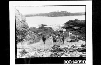 Several people exploring the rocky foreshore