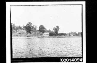 View across still water of a wooden church at the foreshore