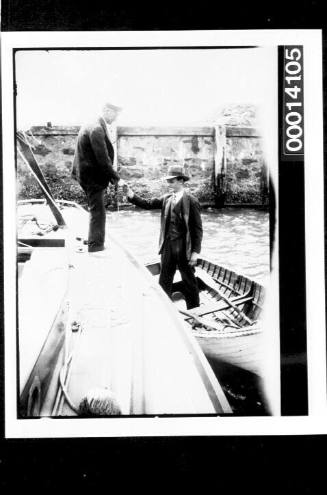 Man greeting Harold Nossiter Snr from a dinghy beside UTIEKAH II