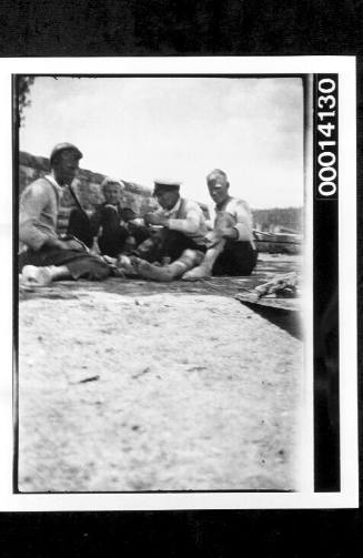 Crew of Harold Nossiter's UTIEKAH II sitting on the shore