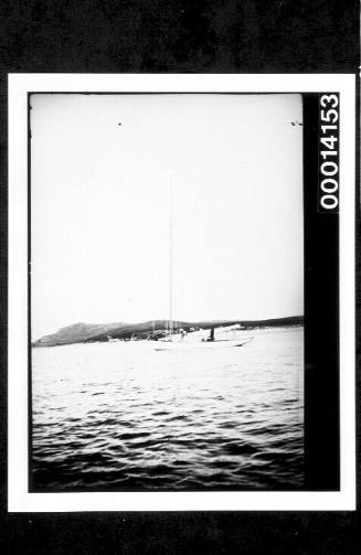 Distant port side view of a yacht at anchor