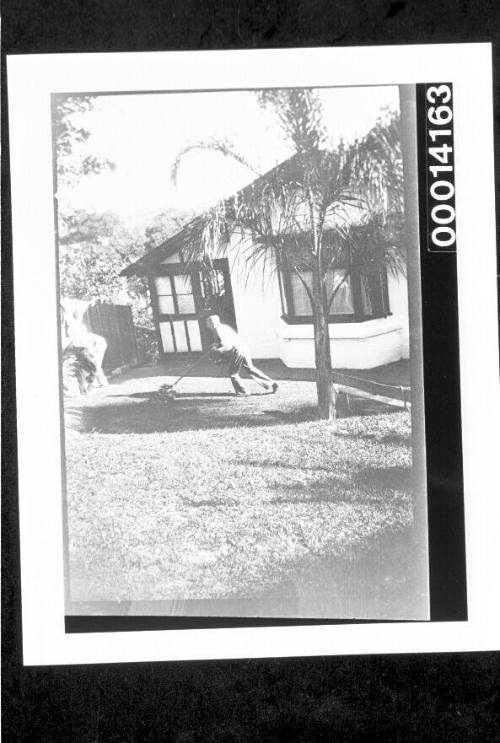 Man mowing the lawn of a home