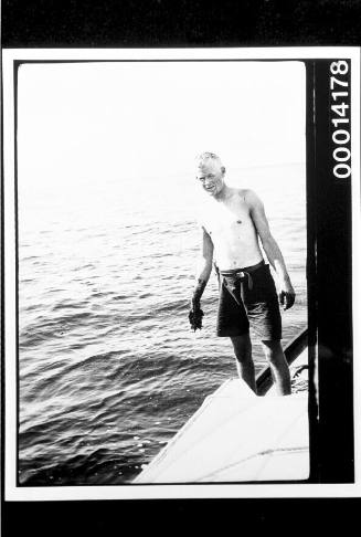 Young man with dirty hands on the deck of a yacht