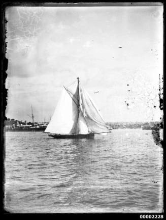 A gaff cutter sailing on Sydney Harbour, New South Wales, with other vessels visible in the background