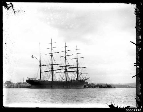 Four masted barque berthed at a wharf at an unknown harbour