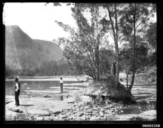Two men and a dog possibly standing on the Hawkesbury River NSW