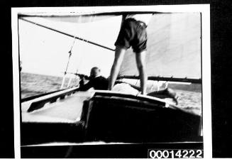 Man shooting a rifle at sea off the deck of yacht UTIEKAH II