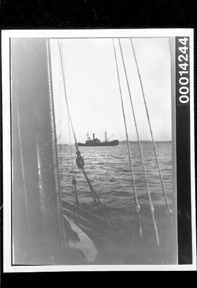 View of a passing cargo ship from the deck of yacht UTIEKAH II