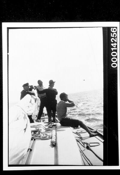 Men on the deck of UTIEKAH II watching something at sea