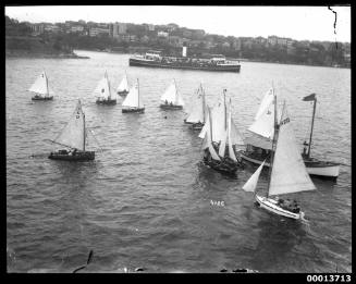 Racing skiffs round a motor launch on Sydney Harbour