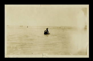 Man and a woman sitting in the water at a beach