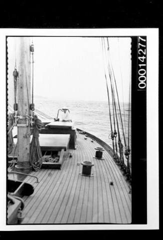 The deck of yacht SIRIUS, Harold Nossiter Snr at the cockpit in the distance