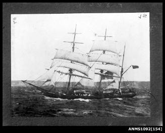 Three masted barque underway with reduced sail