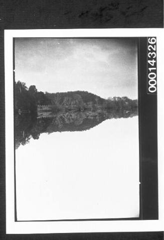 Reflection of hills and trees in the still waters of a river