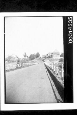 The bitumen road over a bridge looking into a town