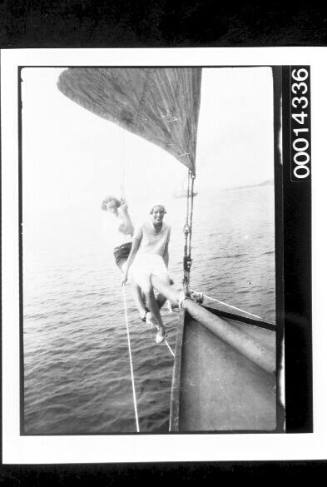 Two young women on the bowsprit of a yacht