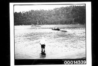 Rowing a dinghy toward a yacht