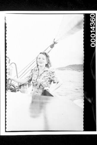 Young woman steering a yacht just off shore