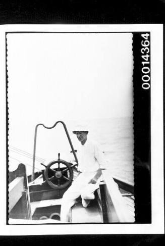 Harold Nossiter Snr at the cockpit of yacht SIRIUS